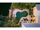 Aerial view of the kidney-shaped pool surrounded by lush greenery and stone patio with lounge chairs at 1243 Starboard Ln, Sarasota, FL 34242