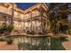 An in-ground pool and hot tub with lounge chairs on a multi-level patio with tropical landscaping and exterior balconies at 1243 Starboard Ln, Sarasota, FL 34242