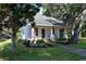 White cottage with a blue door and well-maintained landscaping at 1318 6Th W St, Palmetto, FL 34221