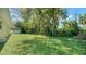 Spacious backyard with grassy area and mature trees at 134 Da Vinci Dr, Nokomis, FL 34275