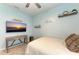 Bedroom with mounted TV, ceiling fan, and calming decor at 14132 Campfire Ct, Parrish, FL 34219