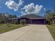 Single-Gathering home with a two-car garage and palm trees at 1661 Atwater Dr, North Port, FL 34288