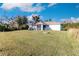 Spacious backyard with grassy lawn, screened porch, and fire pit at 2415 Ancient Rd, North Port, FL 34286