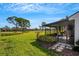 Landscaped backyard with screened patio and golf course view at 3119 Heatherwood Ln, Sarasota, FL 34235