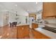 Bright kitchen with wood cabinets, an island, and stainless-steel appliances overlooking the adjacent dining area at 38603 Taylor Rd, Myakka City, FL 34251