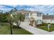 Two-story house with beige exterior, stone accents, and a two-car garage, side yard view at 5331 98Th E Ave, Parrish, FL 34219