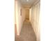 Long hallway with beige carpet and built-in storage at 5701 Soldier Cir # 104, Sarasota, FL 34233