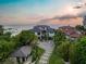 Beautiful home with lush, tropical landscaping and an extended driveway with views of the ocean at sunset at 5861 Gulf Of Mexico Dr, Longboat Key, FL 34228