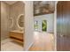 Modern bathroom featuring a unique vanity with a circular mirror and an elegant glass shower at 5861 Gulf Of Mexico Dr, Longboat Key, FL 34228