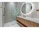 Modern bathroom with a sleek vanity, an illuminated round mirror, and a frameless glass shower at 5861 Gulf Of Mexico Dr, Longboat Key, FL 34228
