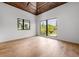 Bright bedroom featuring vaulted wood ceiling, hardwood flooring, and large windows with scenic views at 5861 Gulf Of Mexico Dr, Longboat Key, FL 34228