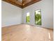 Bright bedroom featuring beautiful hardwood floors and large windows offering views of lush greenery at 5861 Gulf Of Mexico Dr, Longboat Key, FL 34228