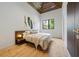 Inviting bedroom featuring a wood ceiling, hardwood floors, and a window overlooking tropical greenery at 5861 Gulf Of Mexico Dr, Longboat Key, FL 34228