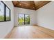 Bright bedroom featuring vaulted wood ceiling, hardwood flooring, and large windows with scenic views at 5861 Gulf Of Mexico Dr, Longboat Key, FL 34228