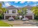 Contemporary home featuring a stylish driveway, manicured lawn, and a two-car garage at 5861 Gulf Of Mexico Dr, Longboat Key, FL 34228