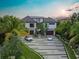 Stunning two-story home with a three-car garage and manicured lawn with palm trees and a circular fountain at 5861 Gulf Of Mexico Dr, Longboat Key, FL 34228