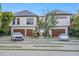 Contemporary home featuring a stylish driveway, manicured lawn, and a two-car garage at 5861 Gulf Of Mexico Dr, Longboat Key, FL 34228