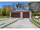 Detached two-car garage featuring a modern design, dual wood doors, and a decorative concrete driveway at 5861 Gulf Of Mexico Dr, Longboat Key, FL 34228