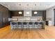 Open kitchen featuring an island with bar seating, custom cabinets, and modern light fixtures at 5861 Gulf Of Mexico Dr, Longboat Key, FL 34228