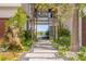 A stone path to the beach with lush landscaping featuring palm trees, flowers, and rock features at 5861 Gulf Of Mexico Dr, Longboat Key, FL 34228