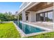 Modern home featuring a sleek, narrow pool extending from the patio into the lush green lawn at 5861 Gulf Of Mexico Dr, Longboat Key, FL 34228