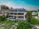 Three-story home with outdoor living spaces, a swimming pool, and beach access at 5861 Gulf Of Mexico Dr, Longboat Key, FL 34228