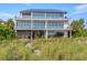 A modern home with floor to ceiling windows has beautiful beach front access at 5861 Gulf Of Mexico Dr, Longboat Key, FL 34228