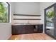 Modern wet bar with custom cabinets, sleek countertops, wine cooler and decorative open shelves at 5861 Gulf Of Mexico Dr, Longboat Key, FL 34228