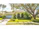 Beautiful yellow home with lush landscaping and a large tree at 7506 Eaton Ct, University Park, FL 34201