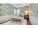 Comfortable bedroom features stylish wallpaper, wainscoting, plantation shutters, and beautiful hardwood floors at 7506 Eaton Ct, University Park, FL 34201