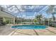 Inviting pool area with screened enclosure, offering lake views and lush landscaping at 7506 Eaton Ct, University Park, FL 34201