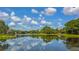 Scenic view of a tranquil lake reflecting the beautiful sky and lush greenery at 7506 Eaton Ct, University Park, FL 34201