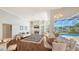Open-concept living room featuring a fireplace, comfortable seating, and views of the pool area at 7506 Eaton Ct, University Park, FL 34201