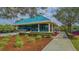 Community center with a teal roof and landscaping at 7506 Eaton Ct, University Park, FL 34201