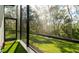 Peaceful screened patio with artificial turf and a view of the backyard at 9260 Swaying Branch Rd, Sarasota, FL 34241
