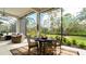 Relaxing screened lanai with outdoor dining set and lush landscaping views at 9260 Swaying Branch Rd, Sarasota, FL 34241