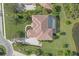 Aerial view of a beautiful home showcasing a tile roof, screened-in pool, lush landscaping, and a serene pond at 10209 Discovery Ter, Bradenton, FL 34212