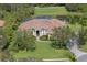 Aerial view of a home featuring a barrel tile roof, well-maintained lawn, and circular driveway at 10209 Discovery Ter, Bradenton, FL 34212