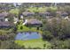 An aerial view of a home near a pond and golf course featuring lush landscaping in a beautiful community at 10209 Discovery Ter, Bradenton, FL 34212