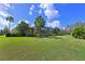 Expansive backyard featuring lush green lawn, mature landscaping, and a screened-in lanai perfect for outdoor living at 10209 Discovery Ter, Bradenton, FL 34212