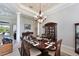 Formal dining room with wooden table, chandelier, and a china cabinet for an elegant and inviting atmosphere at 10209 Discovery Ter, Bradenton, FL 34212