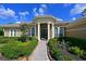 Elegant home entrance featuring a stone walkway, manicured landscaping, and classic architectural columns at 10209 Discovery Ter, Bradenton, FL 34212