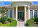 Stately home entrance featuring a grand portico with white columns and manicured landscaping at 10209 Discovery Ter, Bradenton, FL 34212