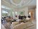 Elegant living room with coffered ceilings, stylish furniture, and access to outdoor spaces at 10209 Discovery Ter, Bradenton, FL 34212