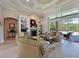 Bright living room with a fireplace, built-in shelving, and sliding glass doors to a lanai at 10209 Discovery Ter, Bradenton, FL 34212