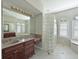 Elegant bathroom with dark wood cabinets, glass block accents, and a soaking tub at 10209 Discovery Ter, Bradenton, FL 34212