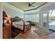 Cozy main bedroom featuring a large bed, hardwood floors, and a door leading to a pool at 10209 Discovery Ter, Bradenton, FL 34212
