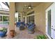 Covered patio area with comfortable seating, ceiling fans, and views of the outdoor pool area at 10209 Discovery Ter, Bradenton, FL 34212