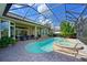 Private screened-in pool and spa with a brick patio, lush landscaping, and a comfortable seating area at 10209 Discovery Ter, Bradenton, FL 34212