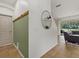 Welcoming hallway with coat hooks, decorative mirror, and tile flooring leading to a bright living area at 12224 Longview Lake Cir, Bradenton, FL 34211